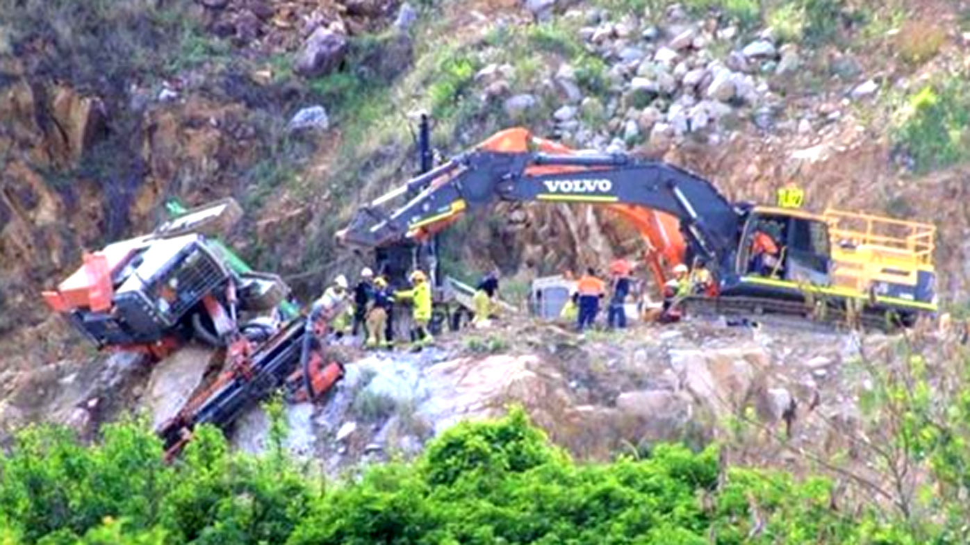 Worker rescued from excavator dangling on quarry ledge in Brisbane - 9news