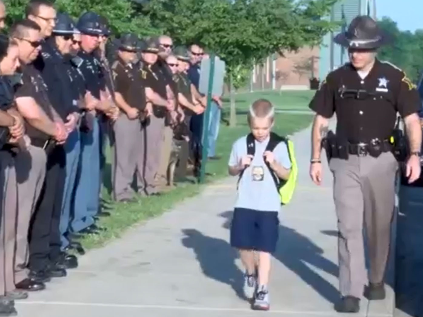 Dozens of police form guard of honour for boy whose father died