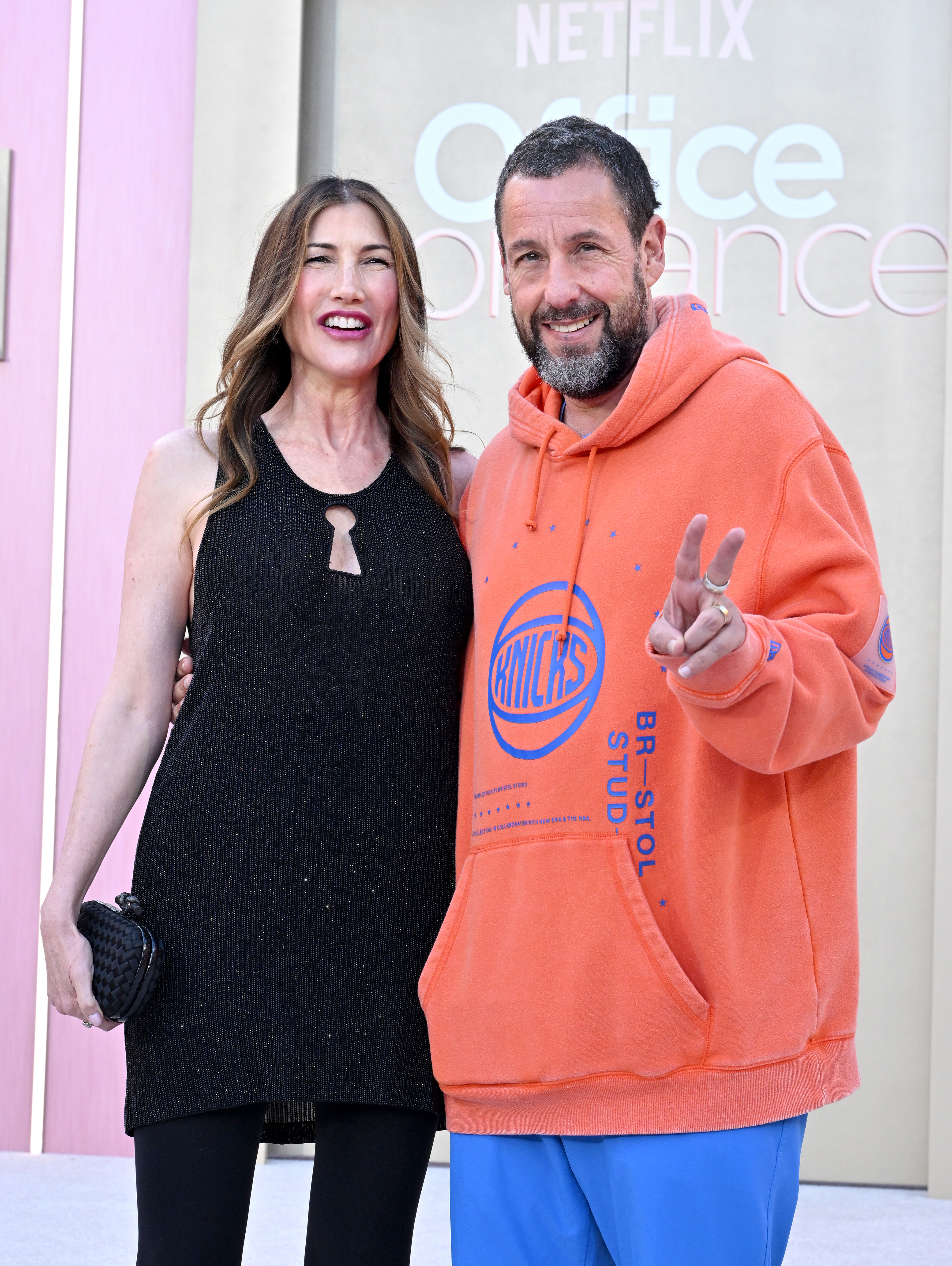Adam Sandler slammed for 'embarrassing' display at wife's premiere as he shows up in a tracksuit and sports hoodie