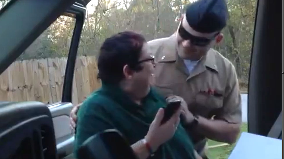 A soldier sneaks up on his mother as she reads a card he had sent her while on a foreign deployment.