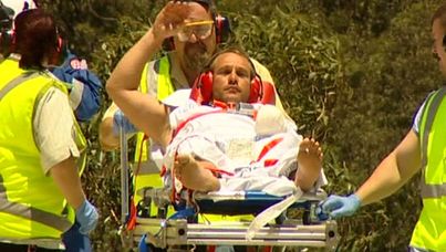 Rescuers help a surfer who was attacked by a shark.