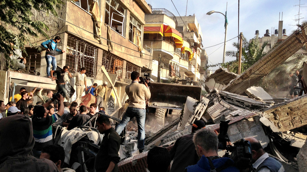 Bystanders take photos after a bomb blast that killed 12 people. (Photo: Peter Stefanovic, Nine News)