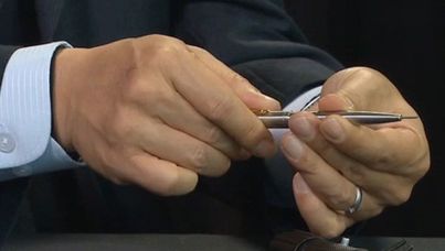 An official shows how to use a pen containing a lethal dart.
