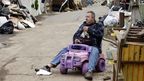 Volodymyr Krupa takes a cigarette break on his street while cleaning out his flood damaged home in the Staten Island. (AAP)