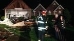 Emergency crews help a couple after the storm tore the front of their house off in Charles County.