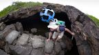 A man scrambles out of a lava tunnel with a Street View Trekker camera after collecting imagery of lava landscapes. (AAP)