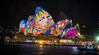 A projection shows a colourful cartoon face. (AAP)