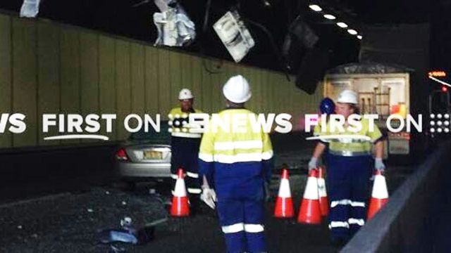 Workers assess the damage in the M5 tunnel. (Nine News)