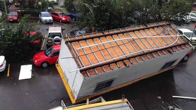 A demountable building is flipped on to its roof at the Hornsby Railway Station during a 'mini tornado'.