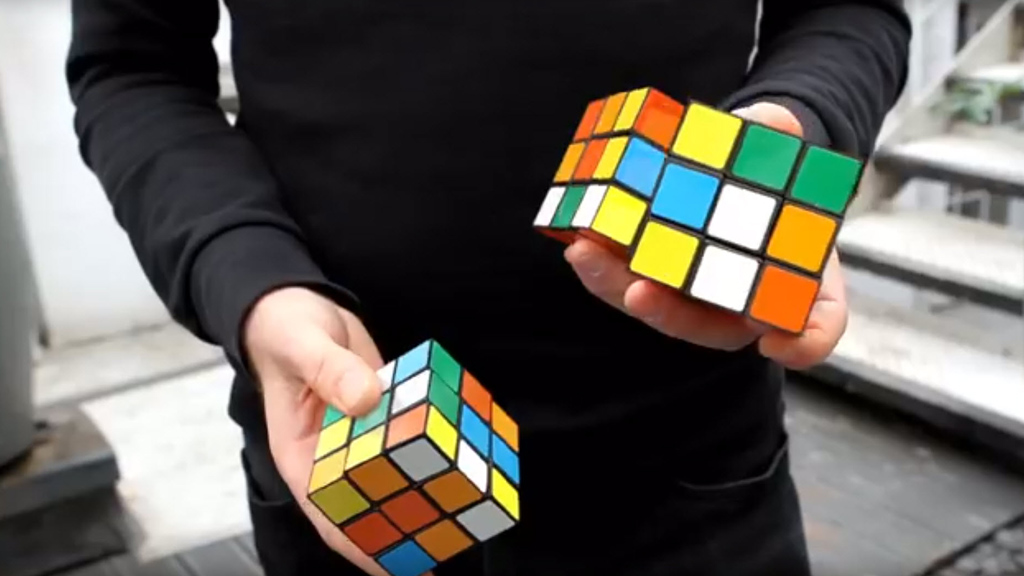 guy solves 3 runix cubes while juggling