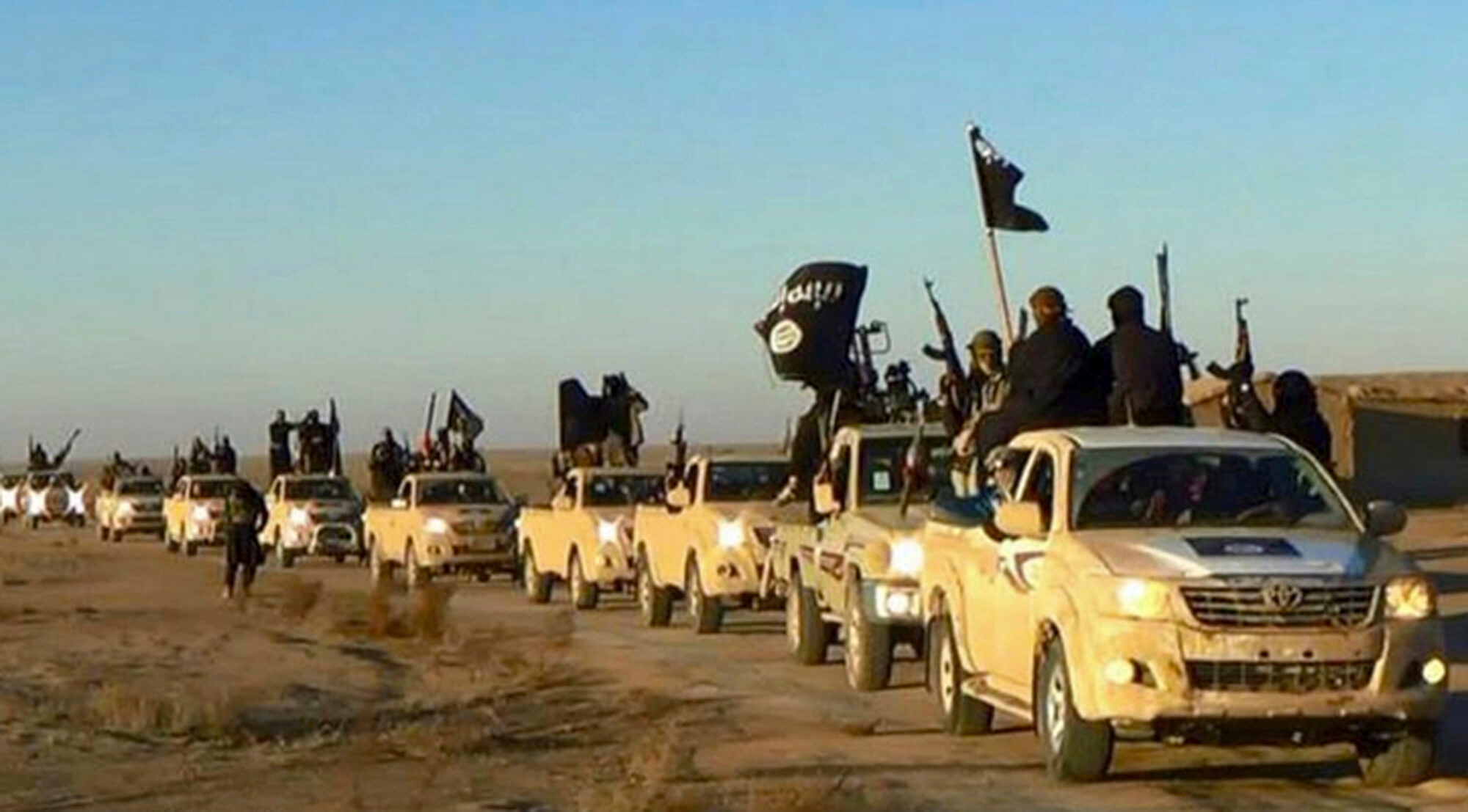 Photo of Islamic state soldiers with guns, flags, vehicles