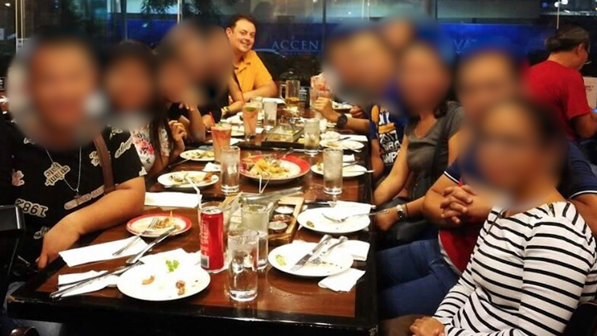 Michael James (back, left) having dinner, believed to be in the Philippines.