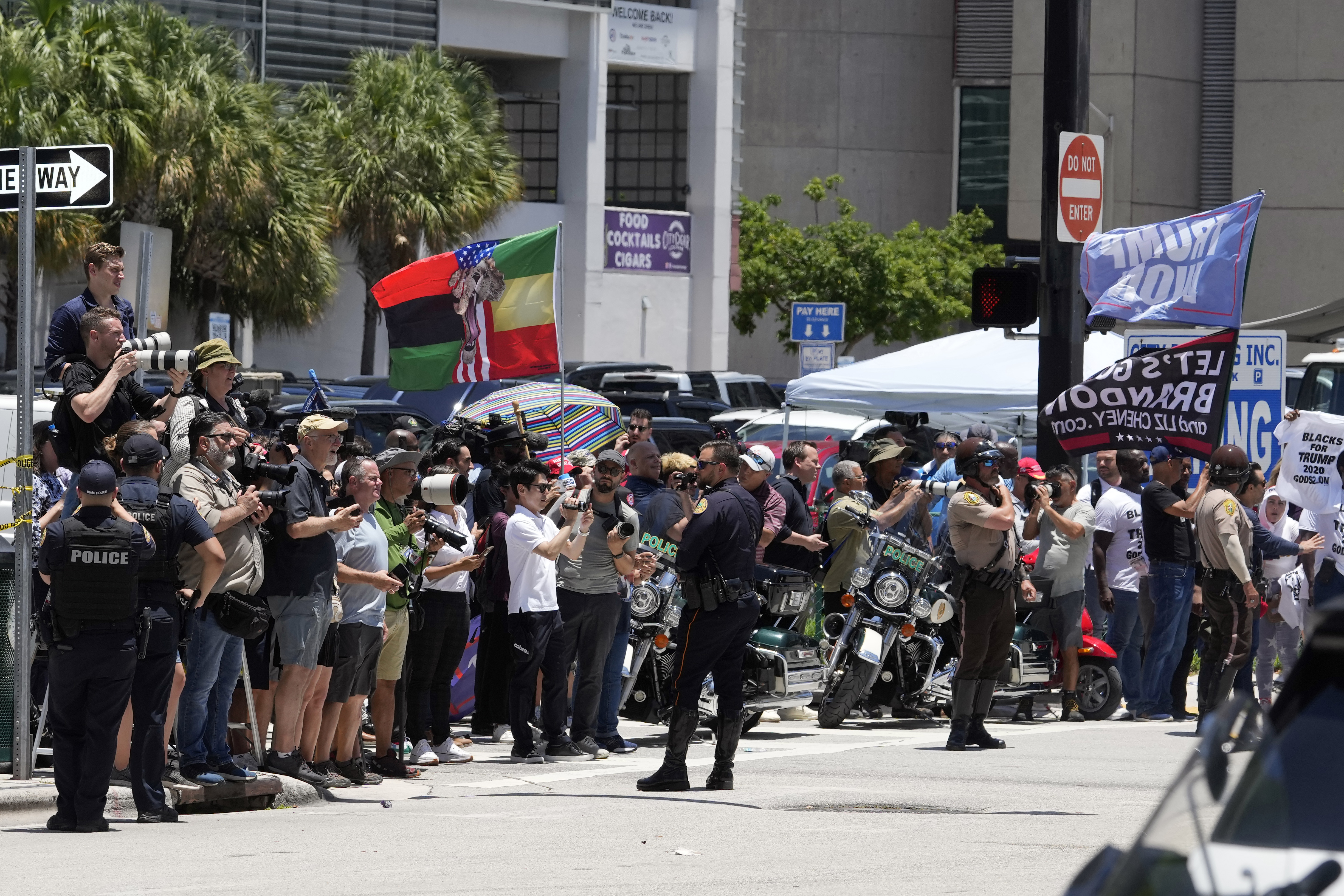 La gente observa cómo la caravana que transporta al expresidente Donald Trump llega al Palacio de Justicia de los Estados Unidos Wilkie D. Ferguson Jr., el martes 13 de junio de 2023, en Miami