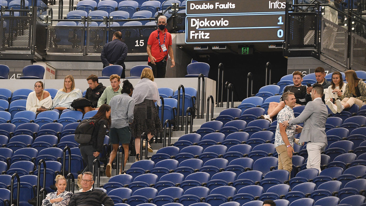 Spectators are asked to leave Rod Laver Arena during the third round match between Serbia's Novak Djokovic and United States' Talyor Fritz at the Australian Open tennis championship in Melbourne, Australia, Friday, Feb. 12, 2021