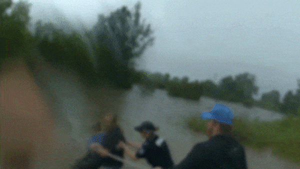 Police wade through deep floodwaters to save woman trapped in car