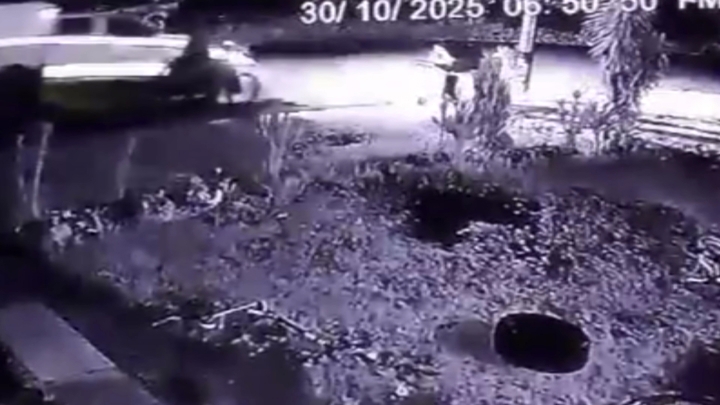 CCTV footage of a police car and a bike beside it at night.