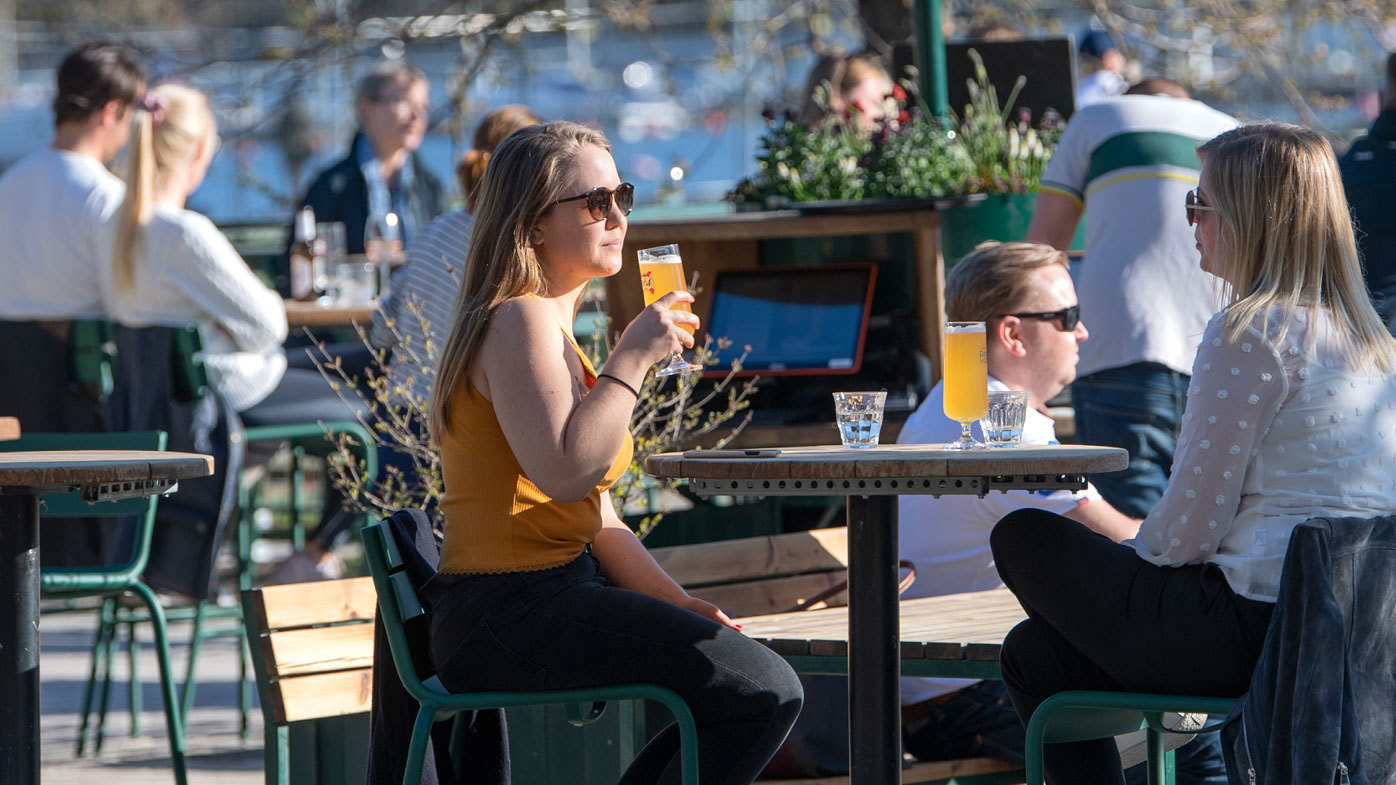 People gather for a drink at an outdoor bar in Stockholm, Sweden.