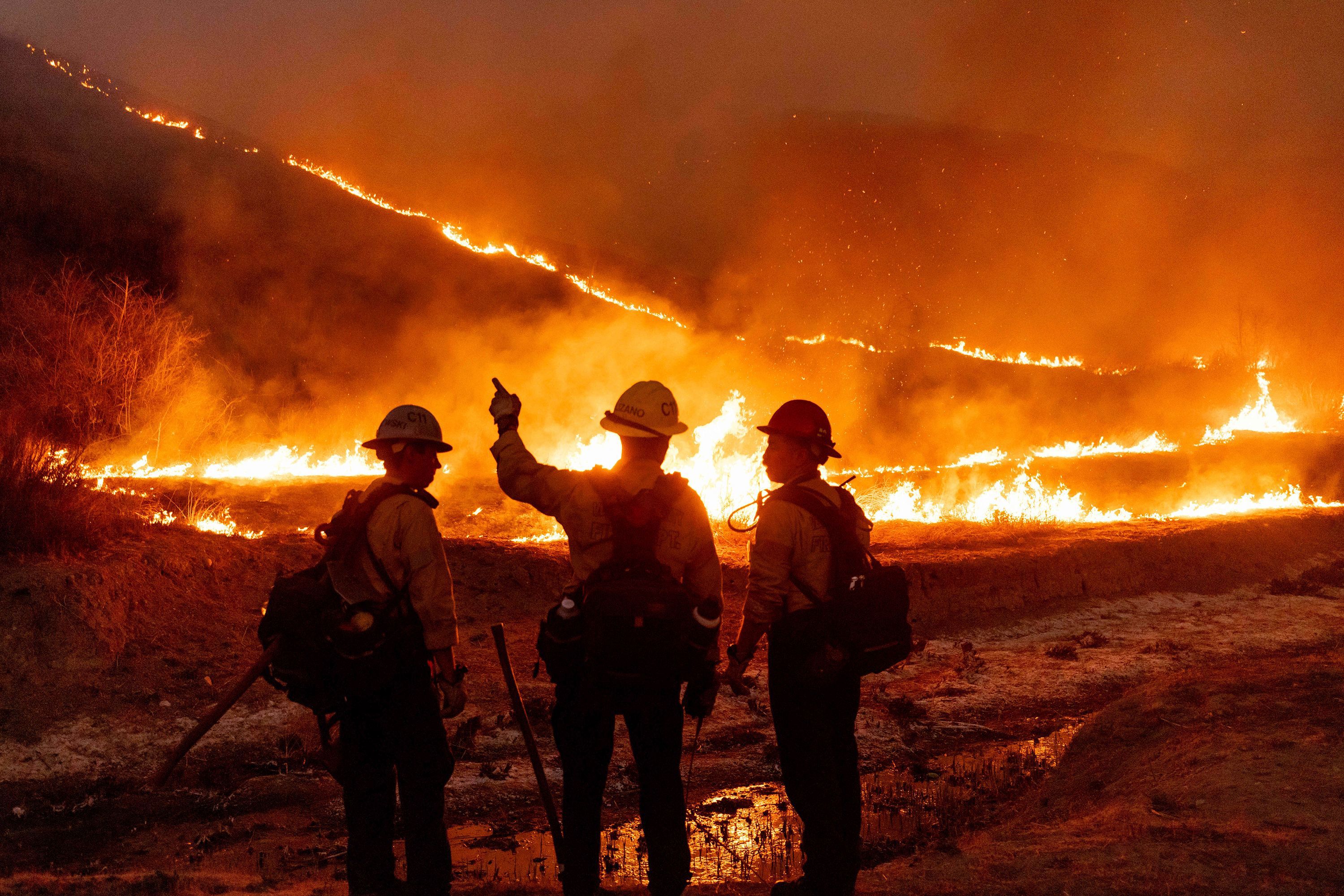 Los equipos de bomberos luchan contra el incendio Kenneth en la sección West Hills de Los Ángeles el 9 de enero.