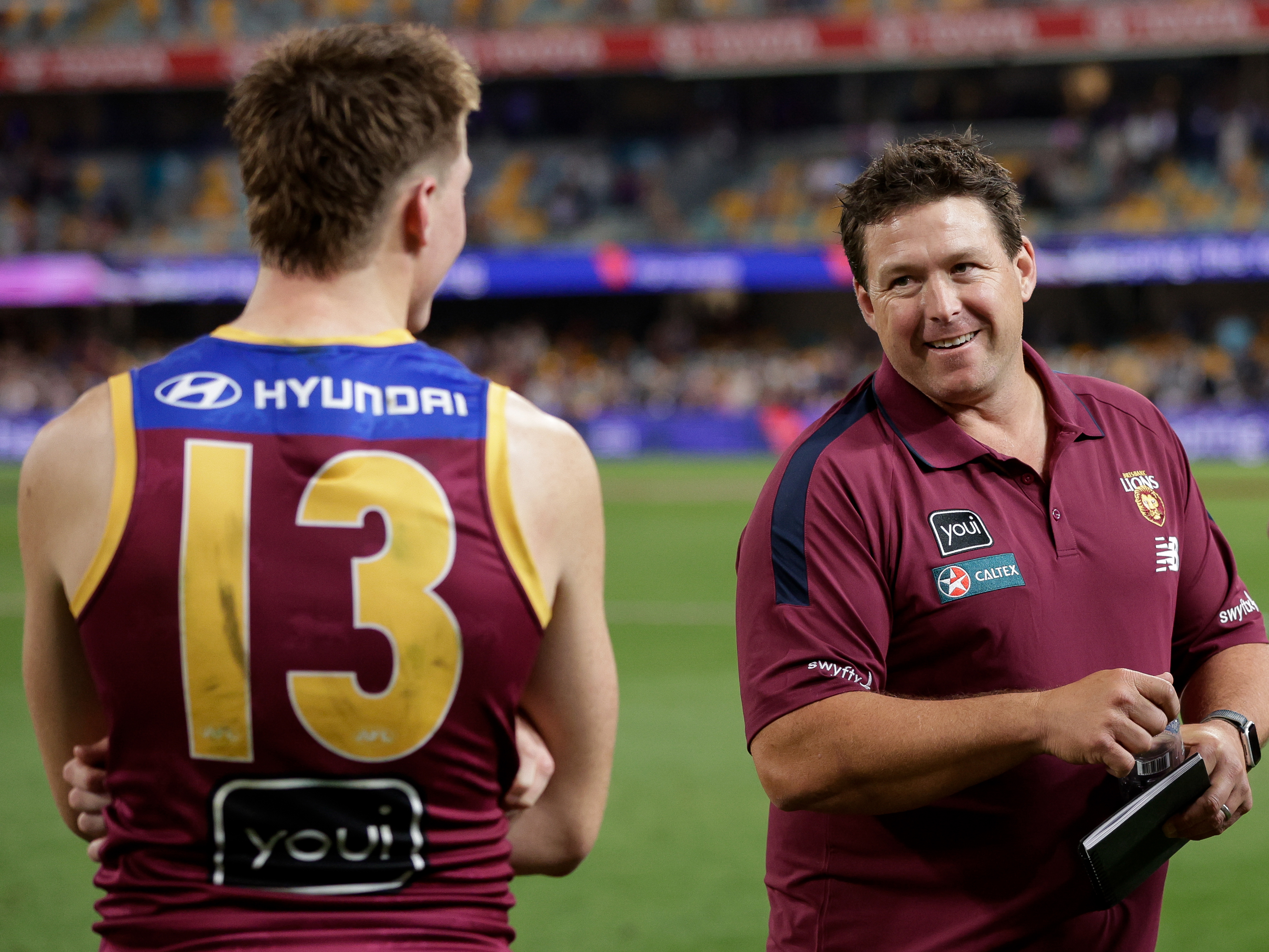 Logan Morris of the Lions and Brisbane Lions assistant Stuart Dew during the finals, 2024.