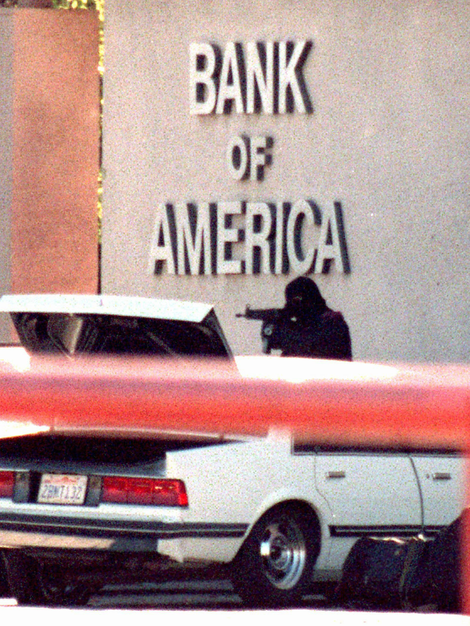 One of the bank robbers fires at LAPD officers with an illegally modified assault rifle.