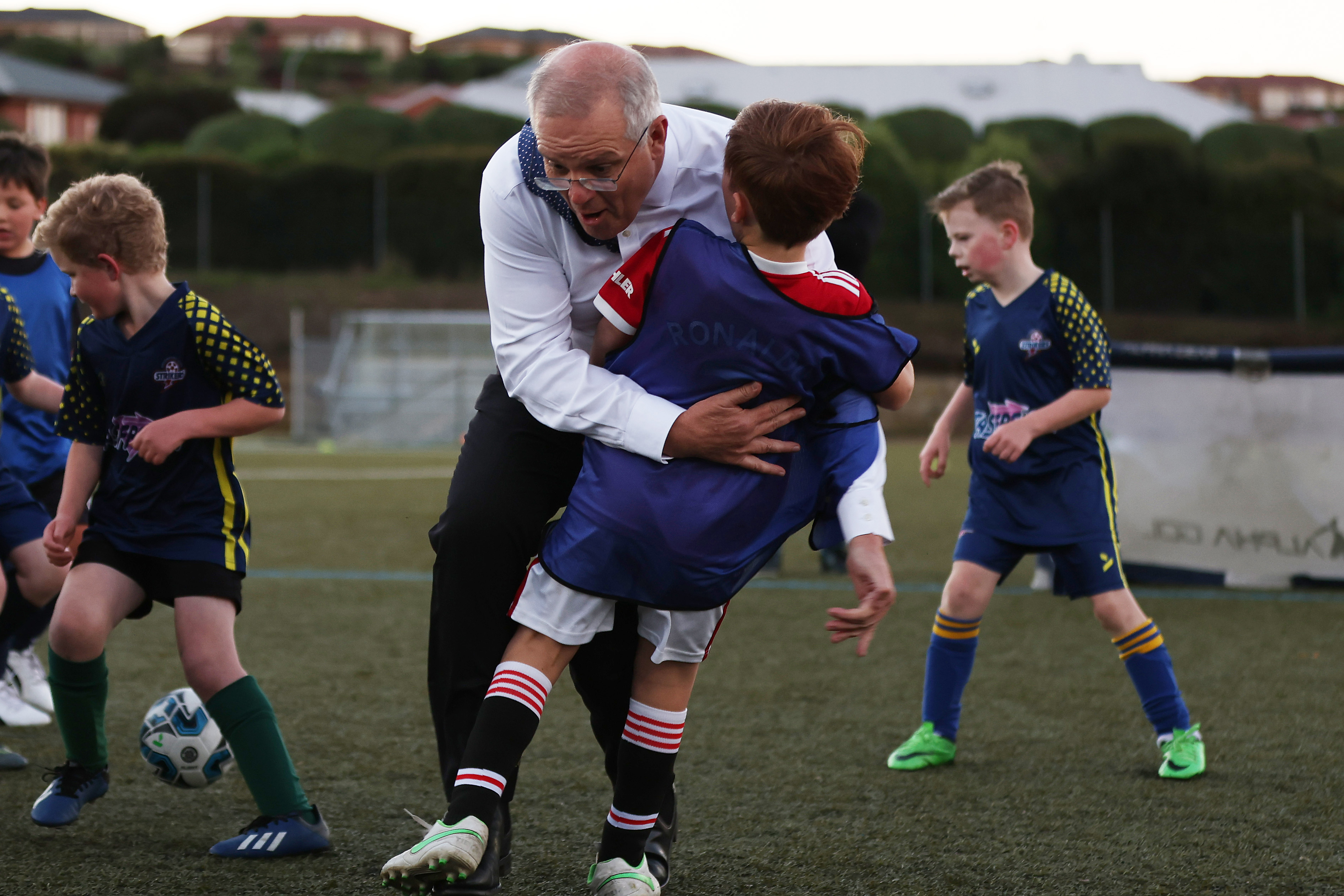 Prime Minister topples child while playing soccer on campaign trail