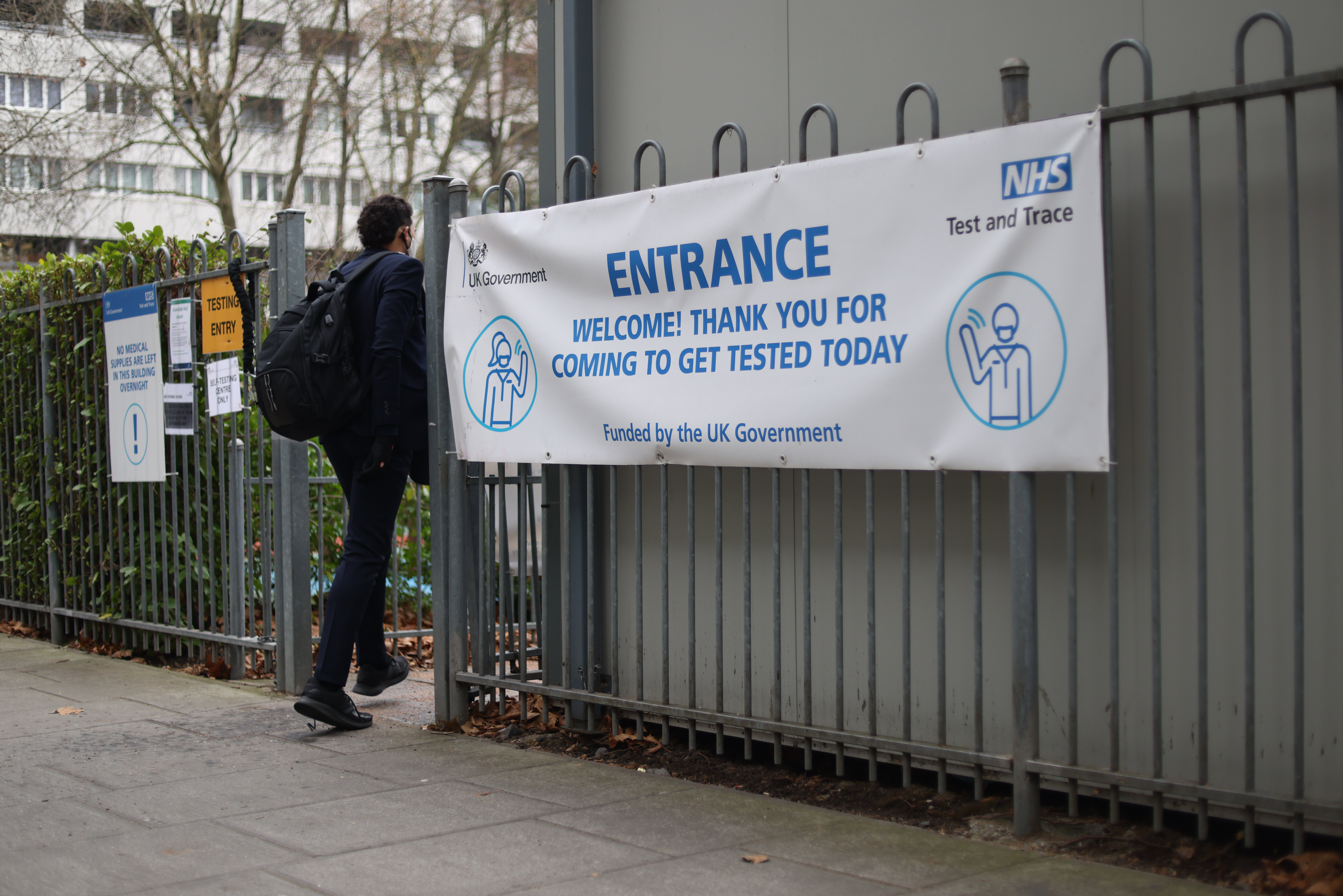 LONDON, ENGLAND - DECEMBER 23: A person walks into a Covid-19 testing centre on December 23, 2021 in London, England. Yesterday, the government reported that it administered 1.06 million first, second and third Covid-19 vaccine jabs, of which 968,665 were boosters. More than half of its adult population has received a booster now, as it races to head off a surge of infections driven by the virus's more contagious Omicron variant. (Photo by Hollie Adams/Getty Images)