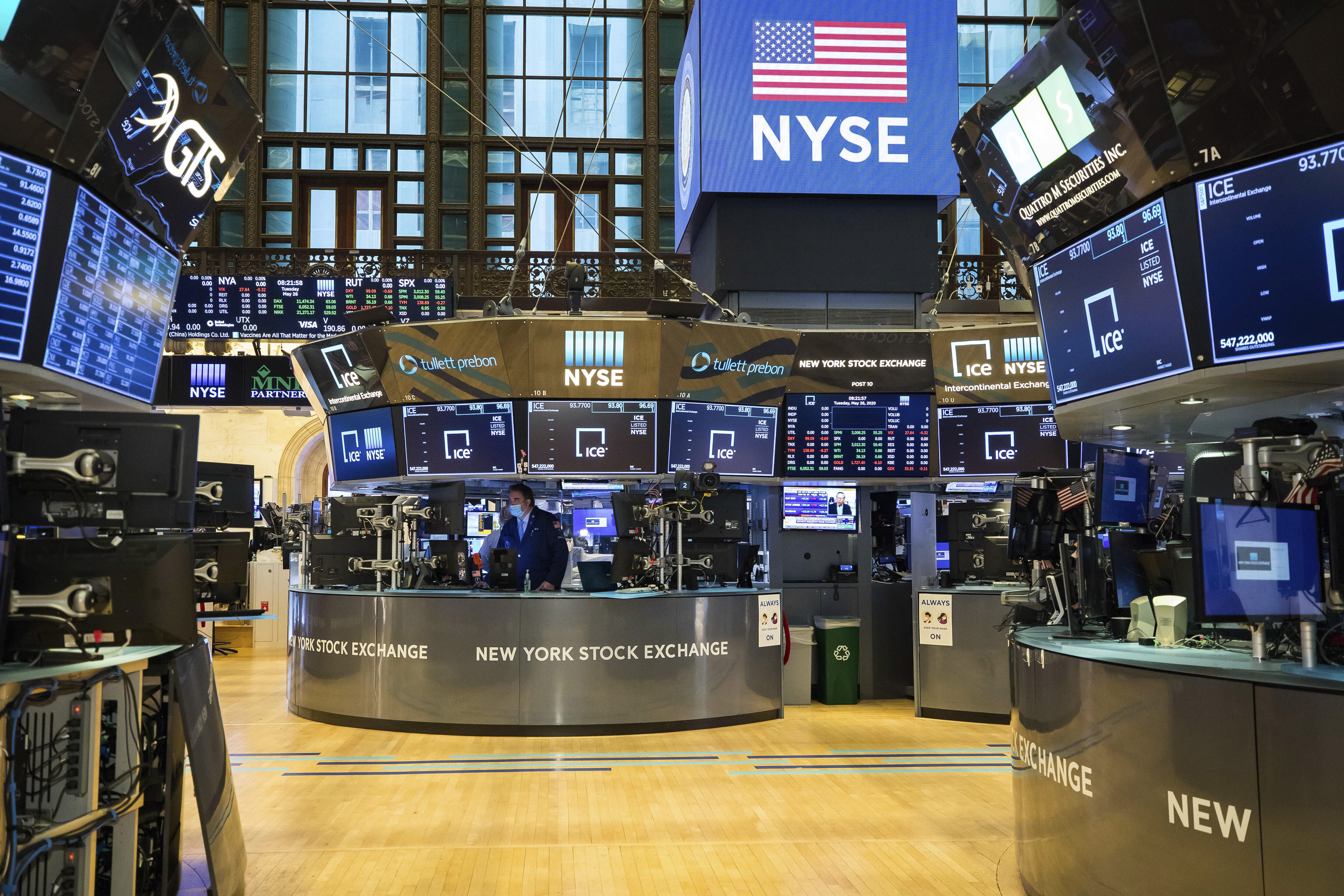 In this photo provided by the New York Stock Exchange, employees work on the partially reopened trading floor, Tuesday, May 26, 2020. Stocks surged on Wall Street in afternoon trading Tuesday, driving the S&P 500 to its highest level in nearly three months, as hopes for economic recovery overshadow worries about the coronavirus pandemic. (Courtney Crow/New York Stock Exchange via AP)