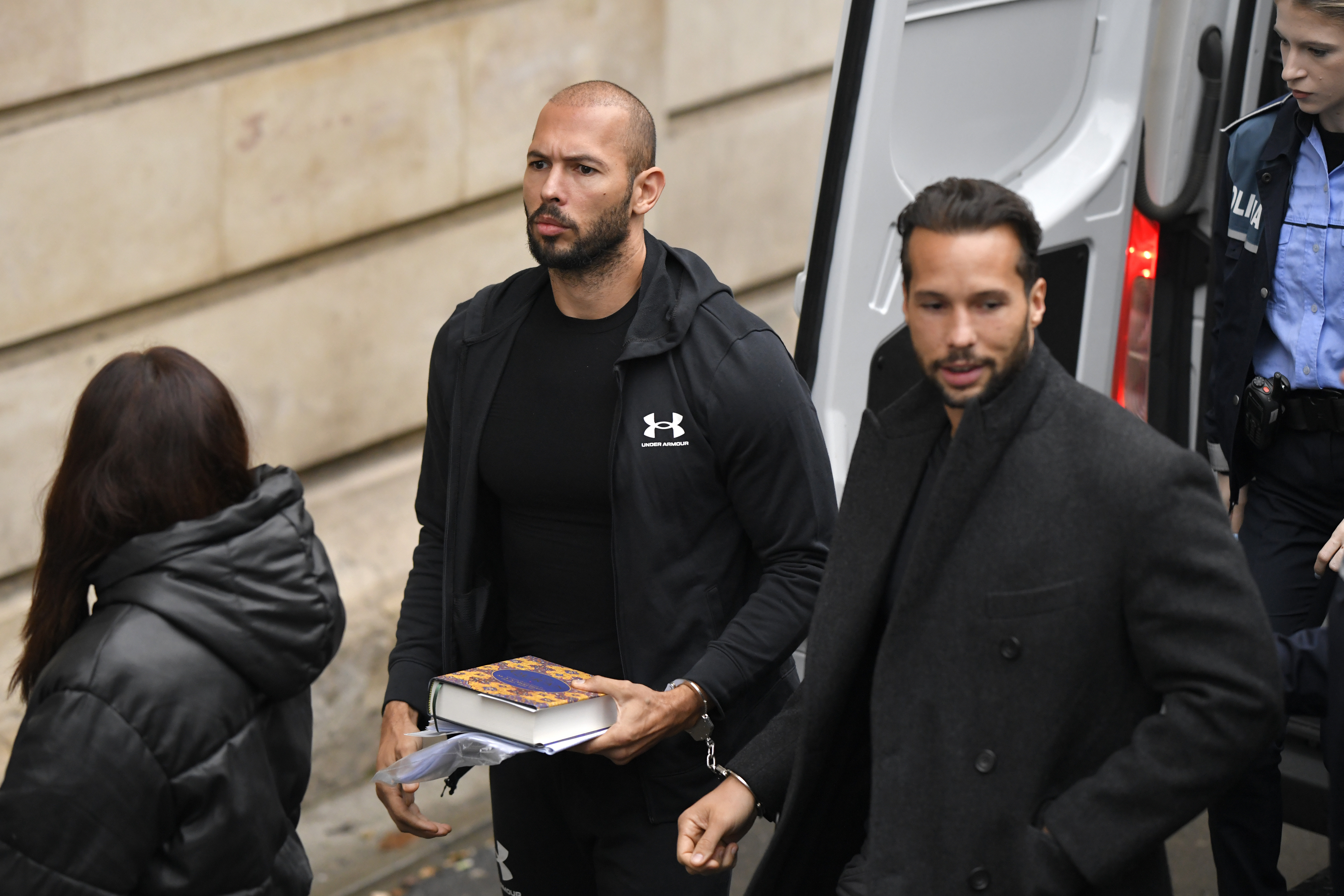 Andrew Tate, centre, and his brother Tristan, right, are brought by police officers to the Court of Appeal, in Bucharest, Romania, Tuesday, Jan.10, 2023. Andrew Tate, a divisive social media personality and former professional kickboxer, was detained last month in Romania on charges of human trafficking and rape, and later arrested for 30 days after a court decision. (AP Photo/Alexandru Dobre)