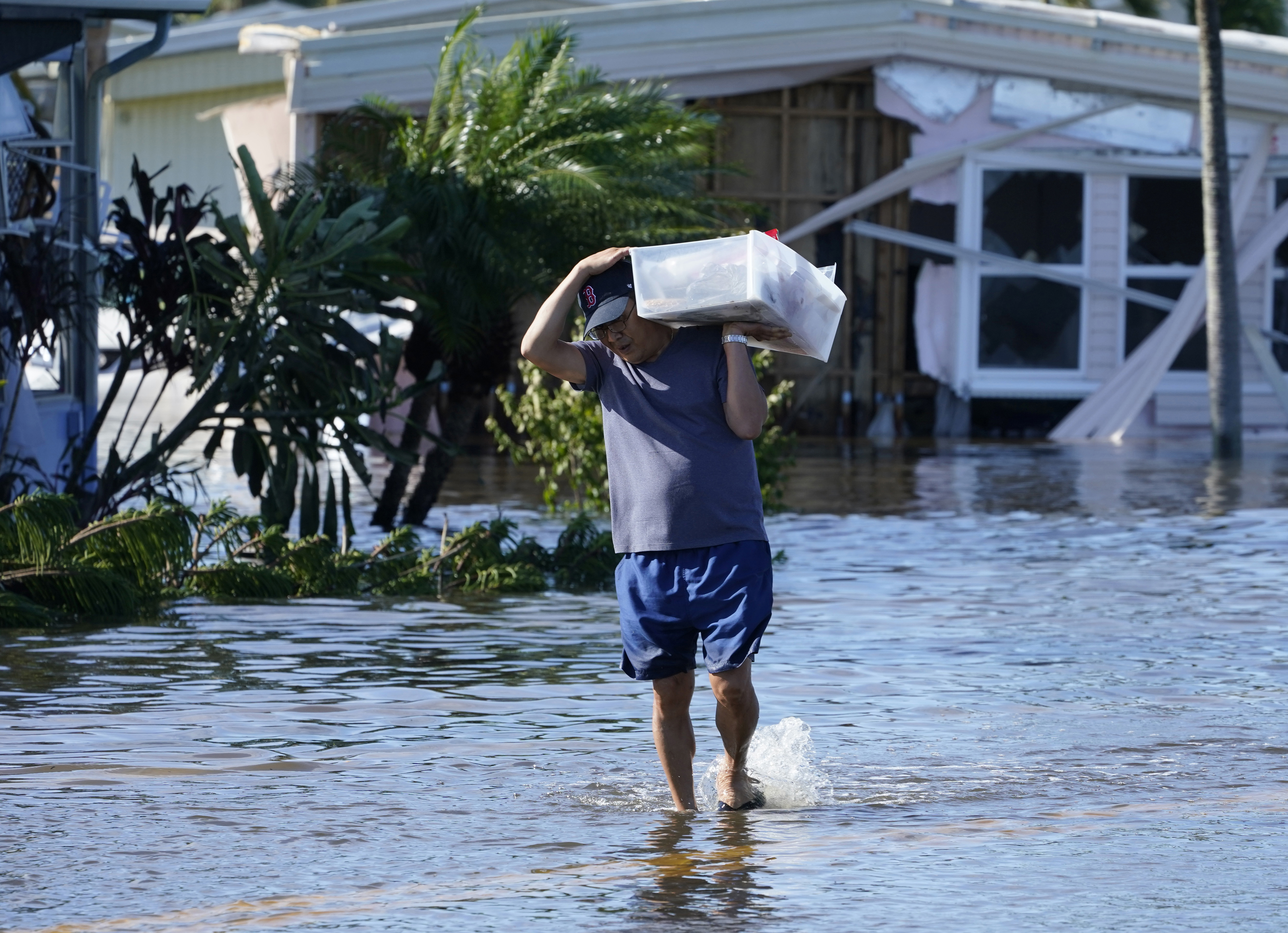 Tom Nugyn carga pertenencias desde su casa inundada después de que el huracán Ian pasara por el área el jueves 29 de septiembre de 2022 en Fort Myers, Florida.