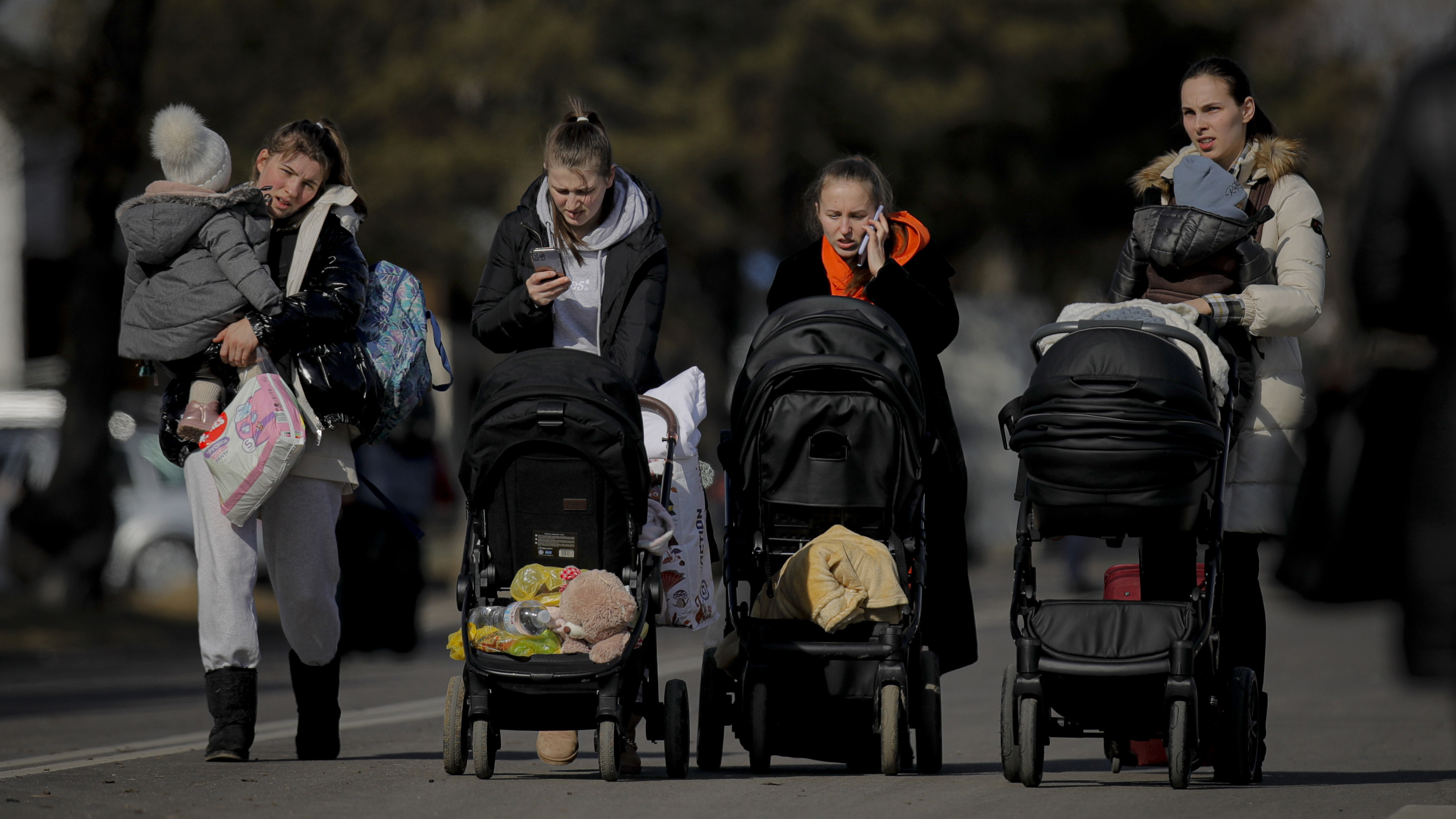 Women push baby strollers after crossing the border from Ukraine at the Romanian-Ukrainian border, in Siret, Romania.