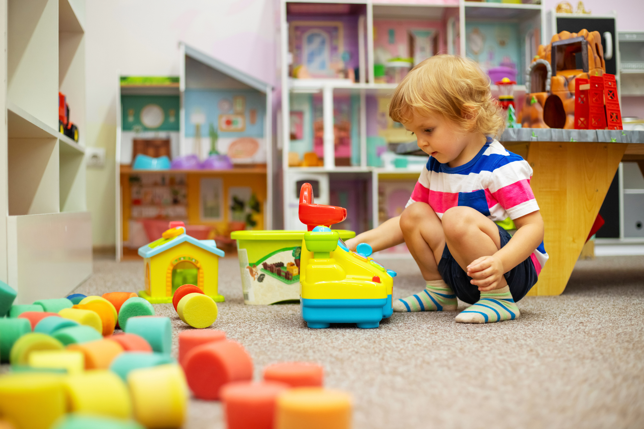 Child playing with colorful toys at daycare / childcare or in kindergarten.