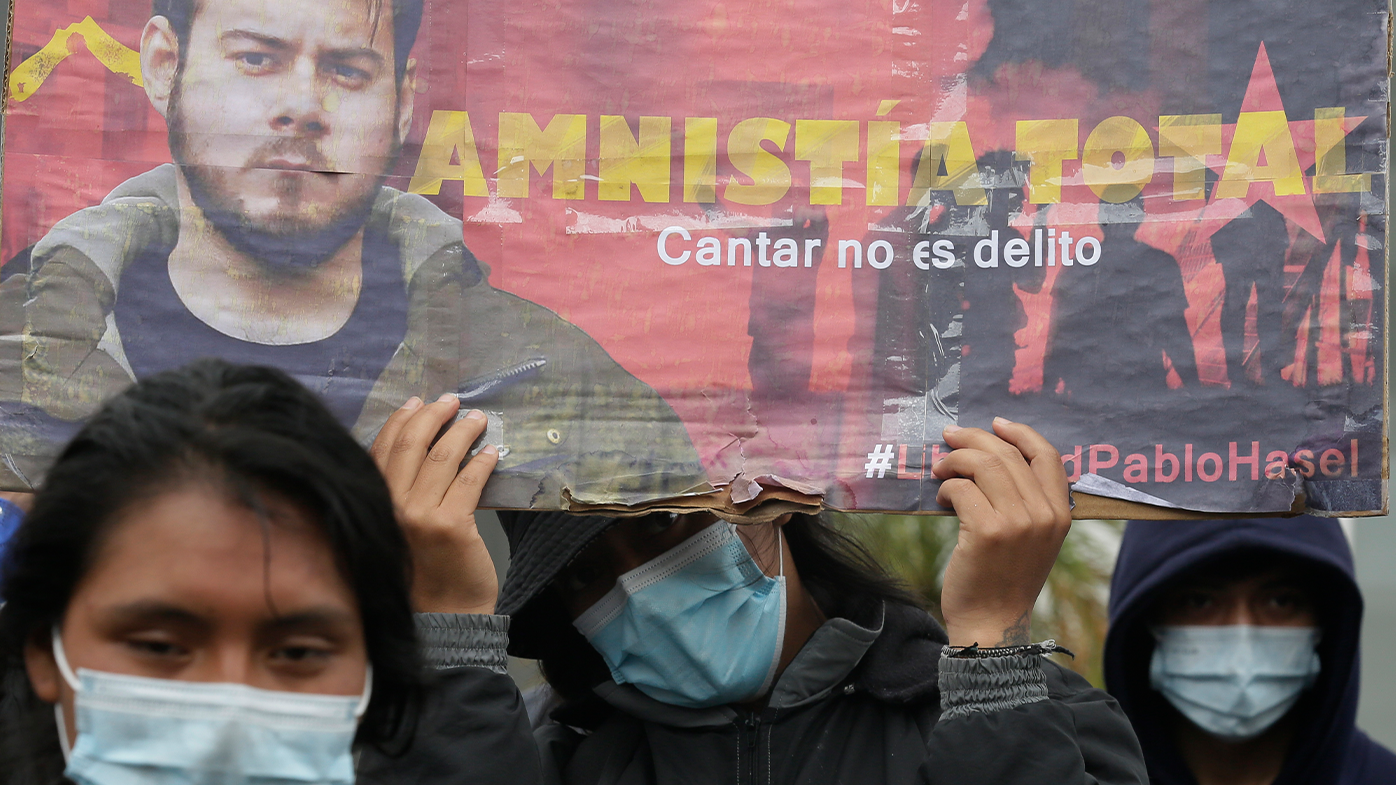 Demonstrators holding a banner supporting rapper Pablo Hasel protest peacefully out side the Spanish consulate in Quito, Ecuador.