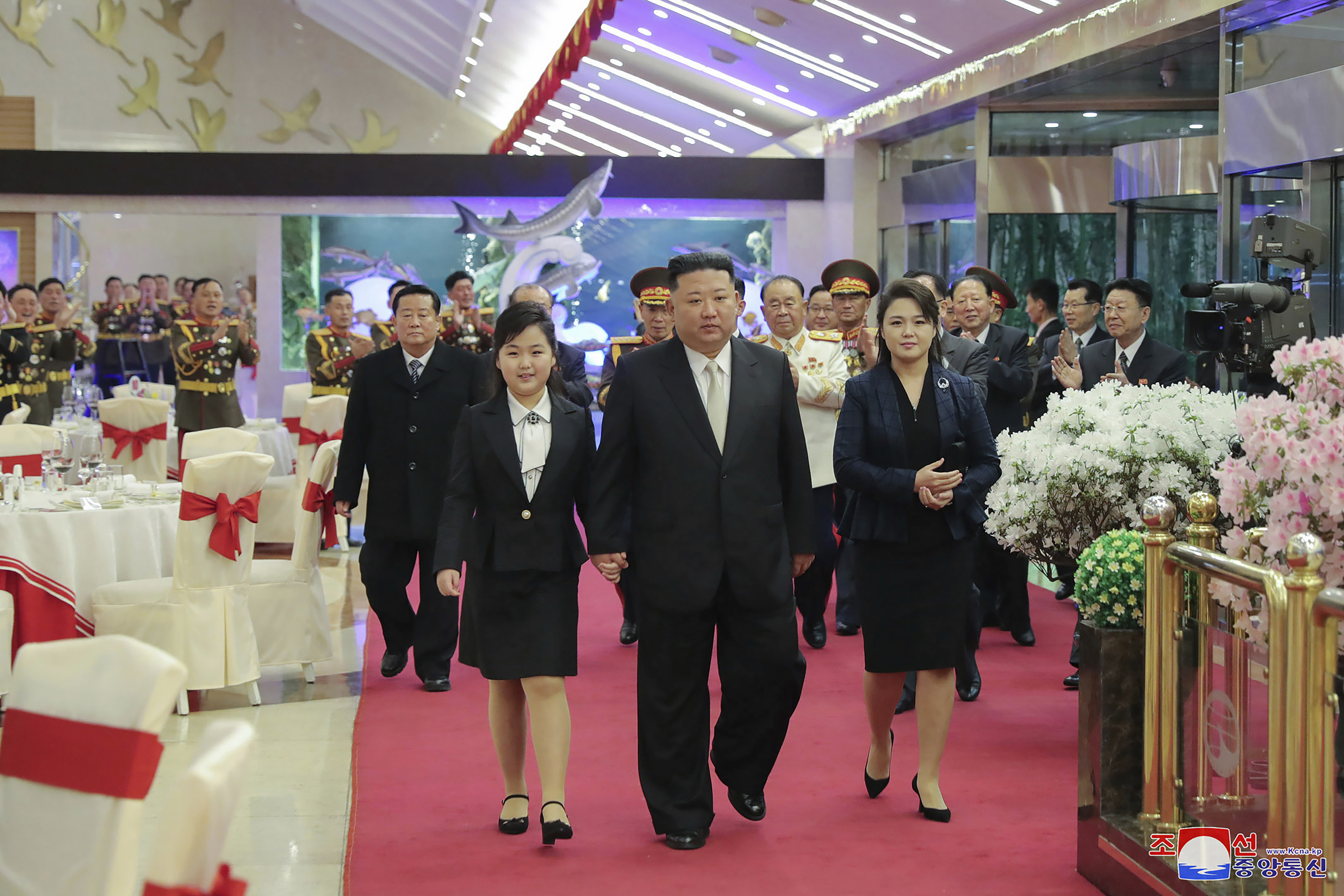 El líder norcoreano Kim Jong Un, centro, con su esposa Ri Sol Ju, derecha, y su hija asisten a una fiesta para conmemorar el 75 aniversario de la fundación del Ejército Popular de Corea en un lugar no especificado en Corea del Norte el martes.