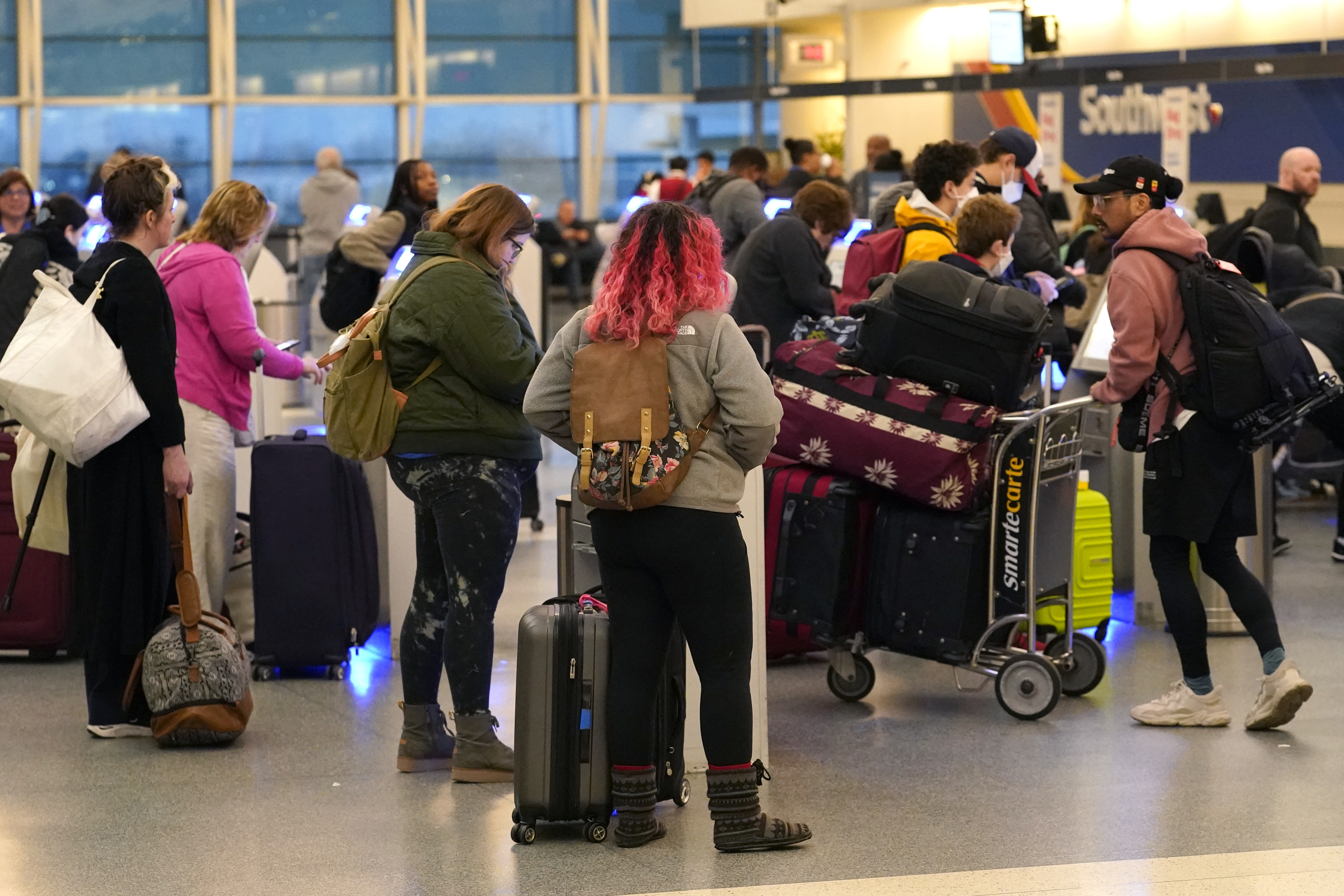 Los pasajeros se registran en los quioscos de autoservicio de Southwest Airlines en el Aeropuerto Midway de Chicago, ya que los retrasos en los vuelos derivados de una interrupción de la computadora en la Administración Federal de Aviación han paralizado los vuelos en los EE. UU. Miércoles, 11 de enero de 2023, en Chicago 