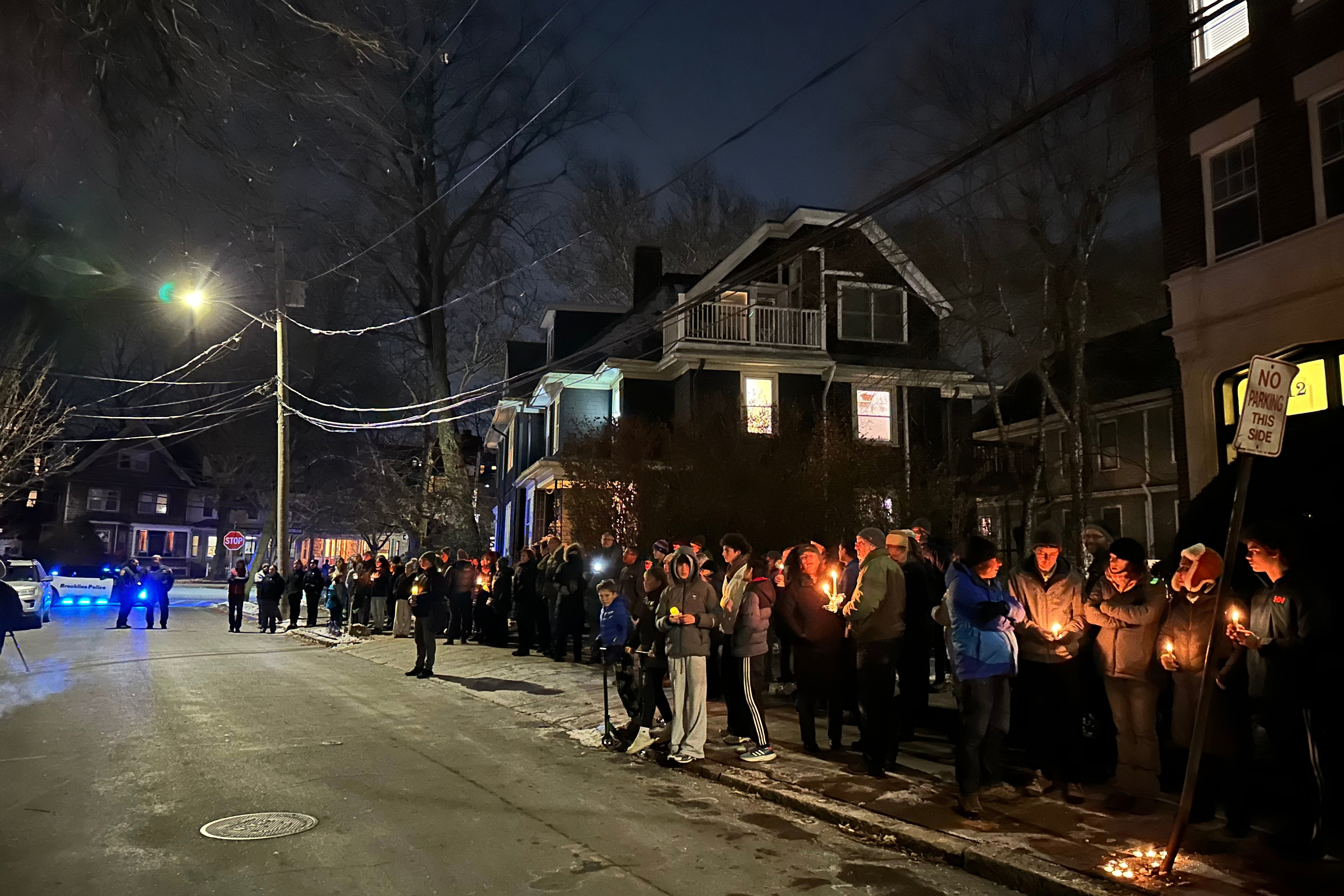 A crowd of people holding candles gather outside the home of Massachusetts Institute of Technology professor Nuno F.G. Loureiro. The Portuguese-born professor was shot and killed on Monday.