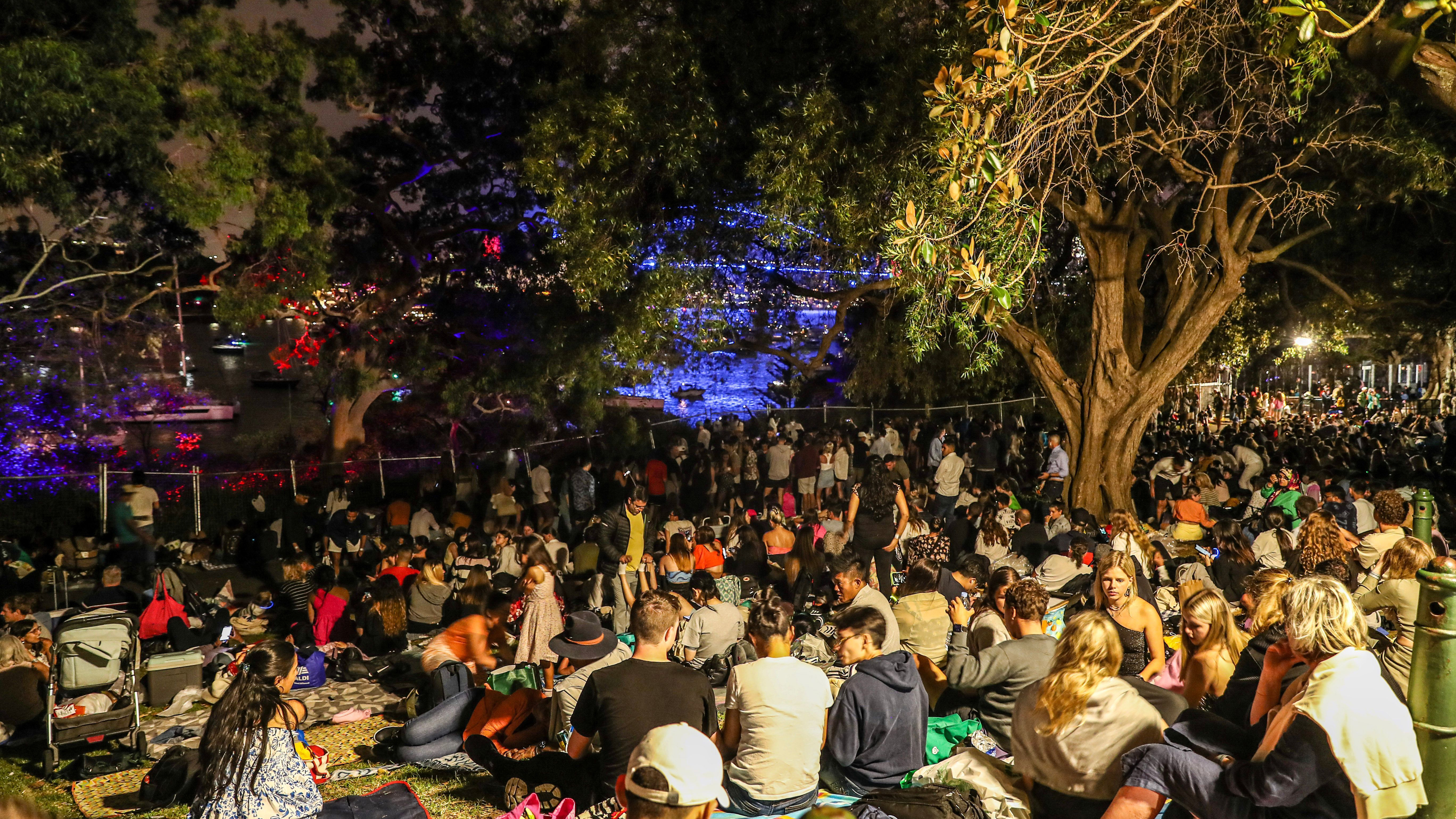 People gather at Sydney Botanic Garden to wait for the New Year fireworks.