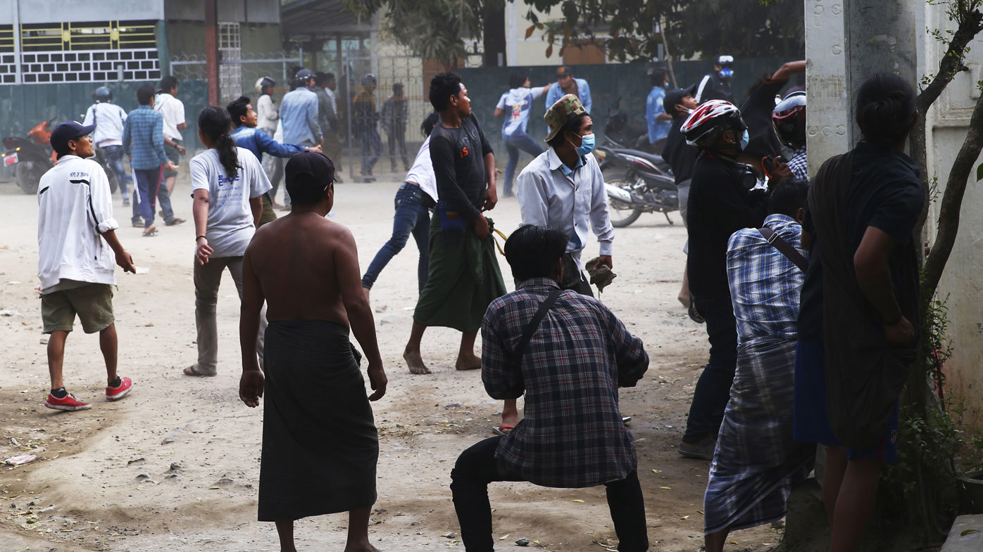Anti-coup protesters react towards police, during a security operation in Mandalay, Myanmar, Saturday, Feb. 20, 2021.
