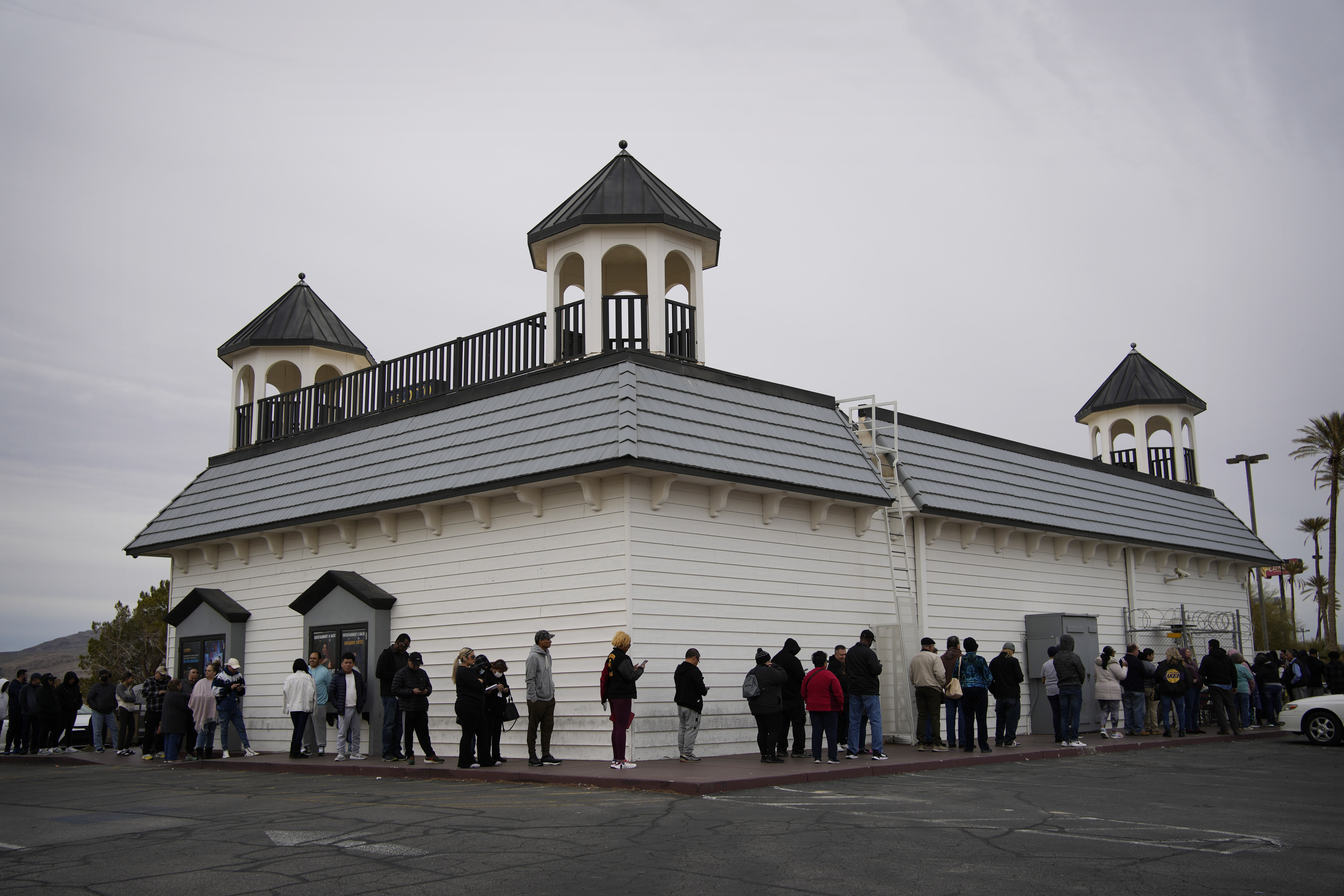 La gente espera en fila alrededor del edificio en Lotto Store en Primm, justo dentro de la frontera de California, el viernes 13 de enero de 2023, cerca de Primm, Nevada. Los jugadores de Mega Millions tendrán otra oportunidad el viernes por la noche para poner fin a meses de pérdidas y finalmente ganar un premio mayor que ha crecido a $ 1.35 mil millones. 