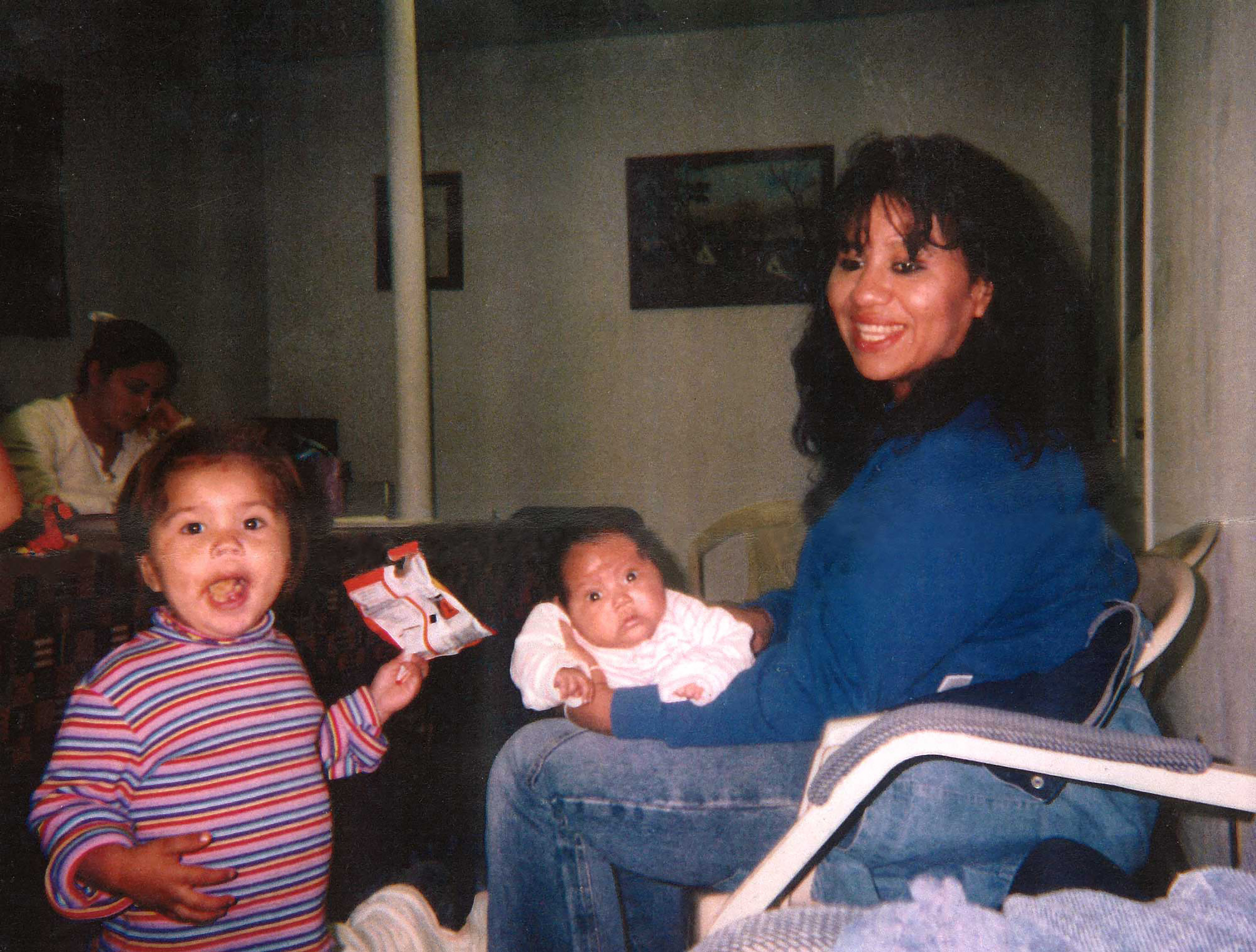 Texas death row inmate Melissa Lucio is holding her daughter Mariah, while one of her other daughters, Adriana, stands next to them. 