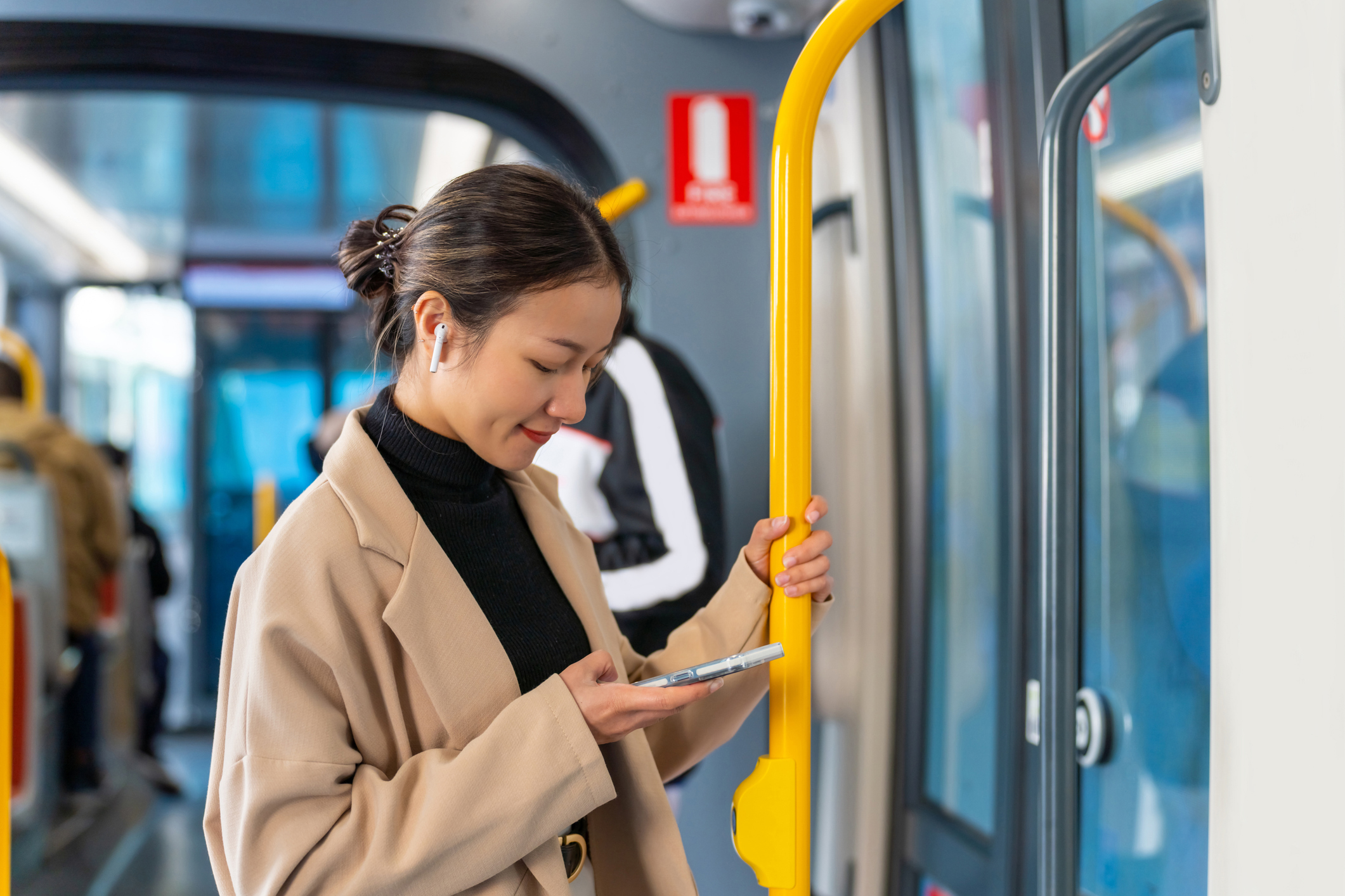 Young woman listening to music on her phone on a bus