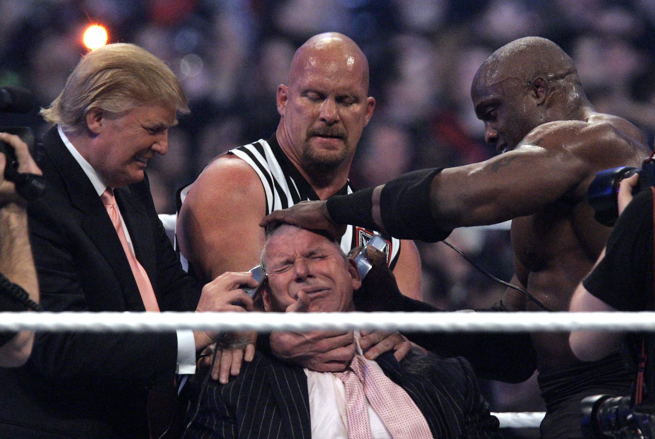 El presidente de la WWE, Vince McMahon, en el centro, sostenido por "Frío como una piedra" Steve Austin, con Donald Trump, izquierda, y Bobby Lashley, derecha, le cortan el cabello después de que Lashley derrotara a Umaga en Wrestlemania 23 en el Ford Field de Detroit, el domingo 1 de abril de 2007. (Foto AP/Carlos Osorio)