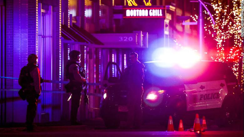 Police stand outside a Lakewood, Colorado, shopping center where the suspected gunman was killed.