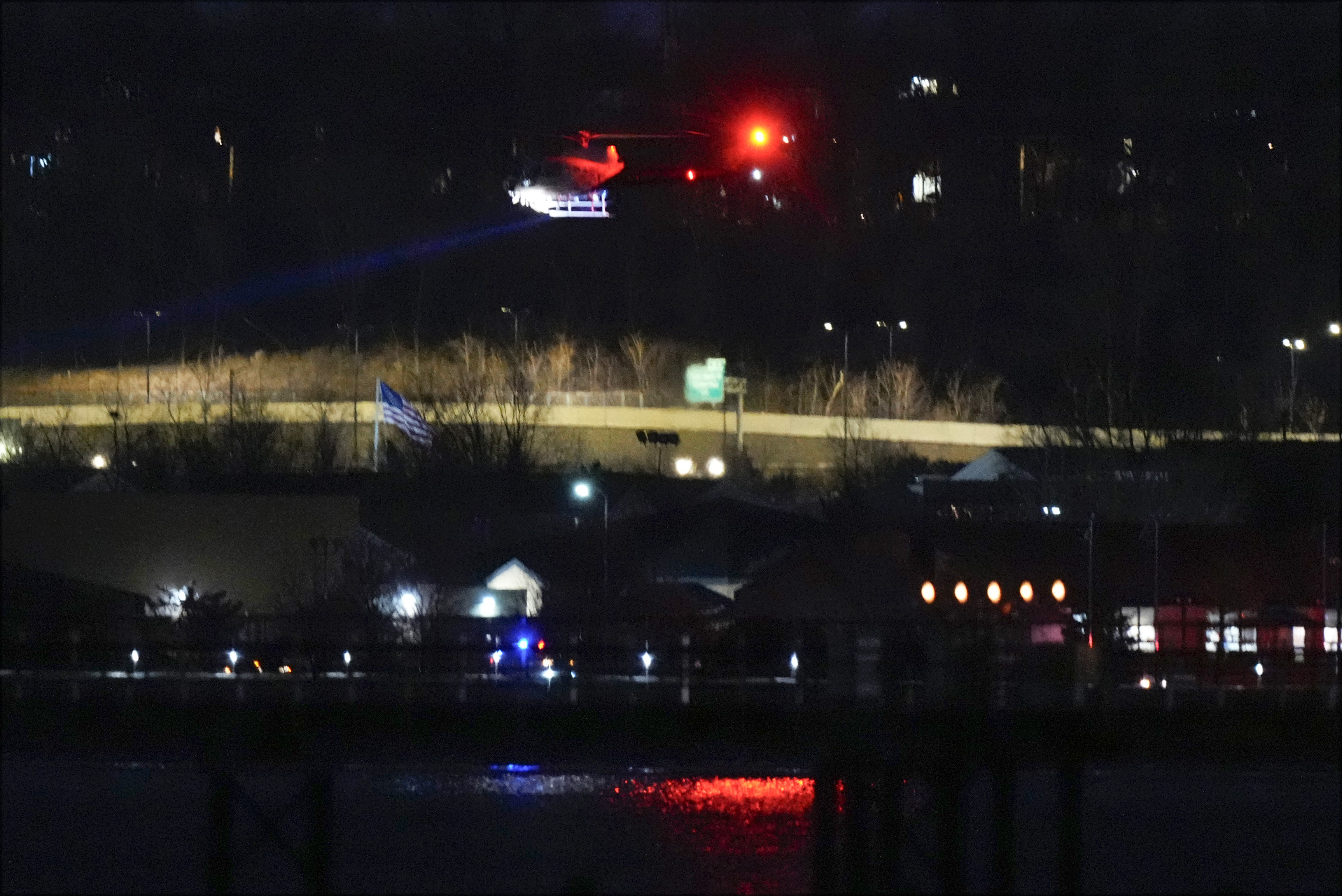 A helicopter uses its searchlight as it flies above the Potomac River near Ronald Reagan Washington National Airport Wednesday, Jan. 29, 2025, in Arlington, Va.