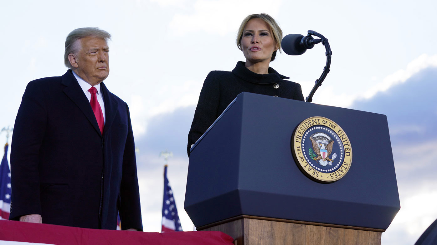 President Donald Trump listens as First Lady Melania Trump speaks before boarding Air Force One at Andrews Air Force Base, Md., Wednesday, Jan. 20, 2021.