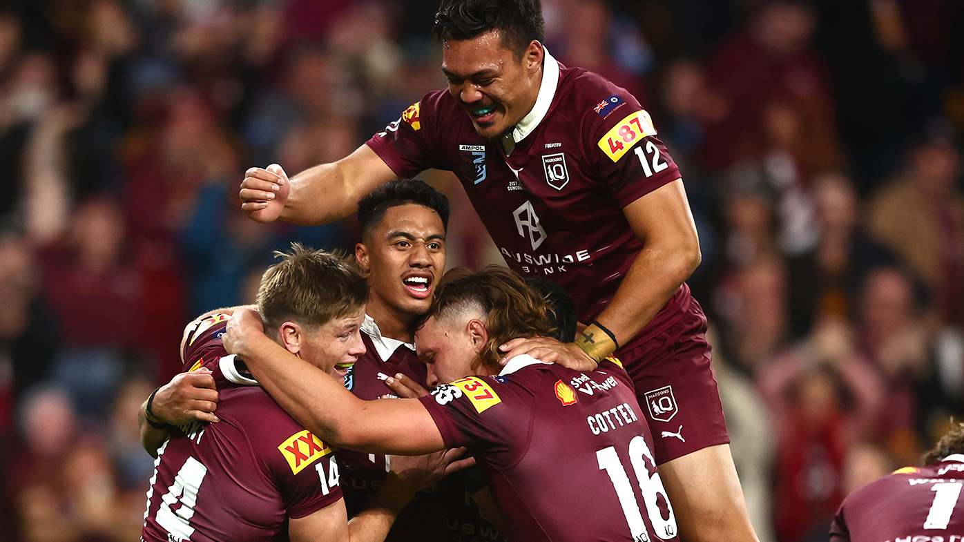 Murray Taulagi of the Maroons celebrates with teammates after scoring a try.