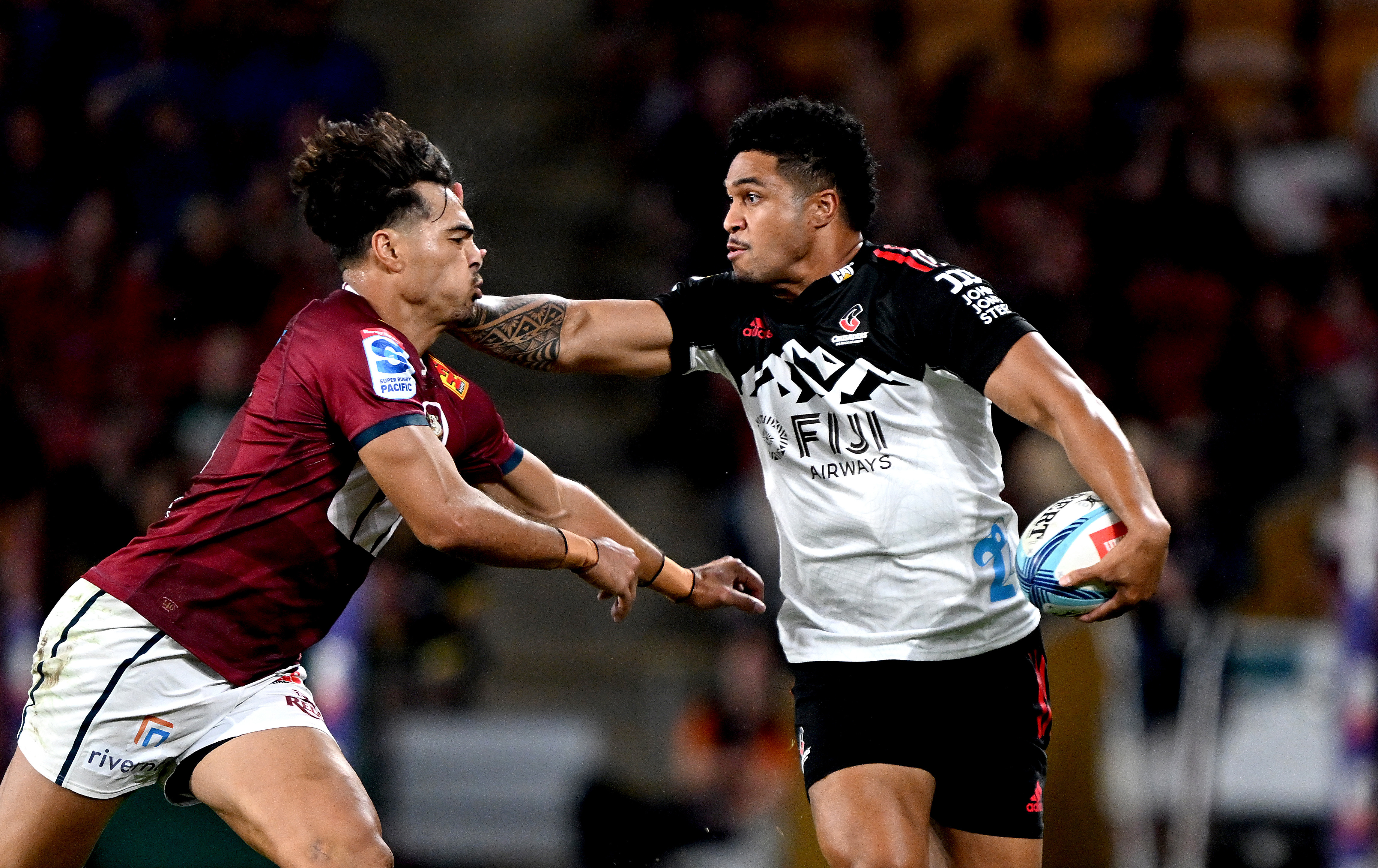 Leicester Fainga'anuku of the Crusaders takes on the defence of Jordan Petaia of the Reds.