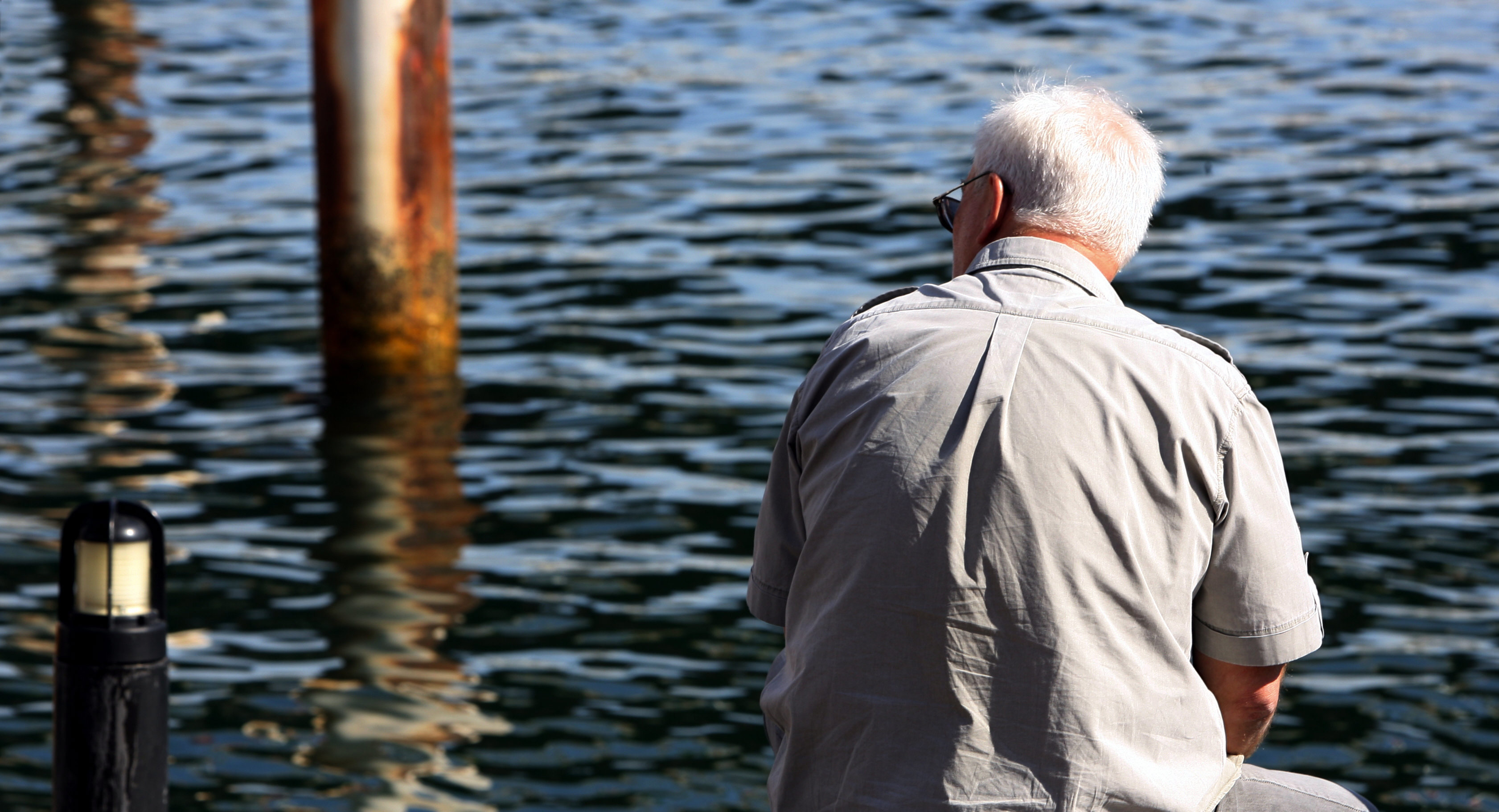 Generic baby boomer sitting by the water at Darling Harbour