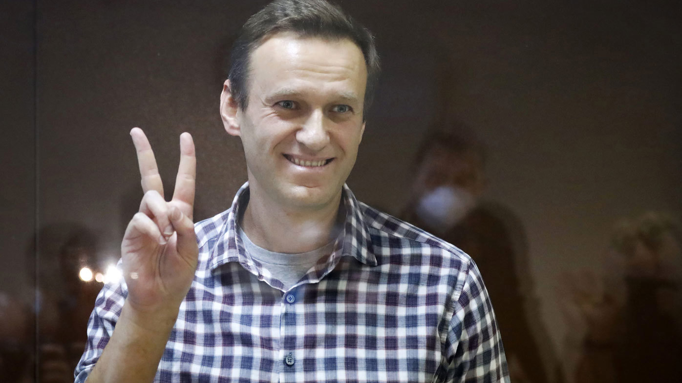 Russian opposition leader Alexei Navalny stands in a cage in the Babuskinsky District Court in Moscow, Russia, Saturday, Feb. 20, 2021.