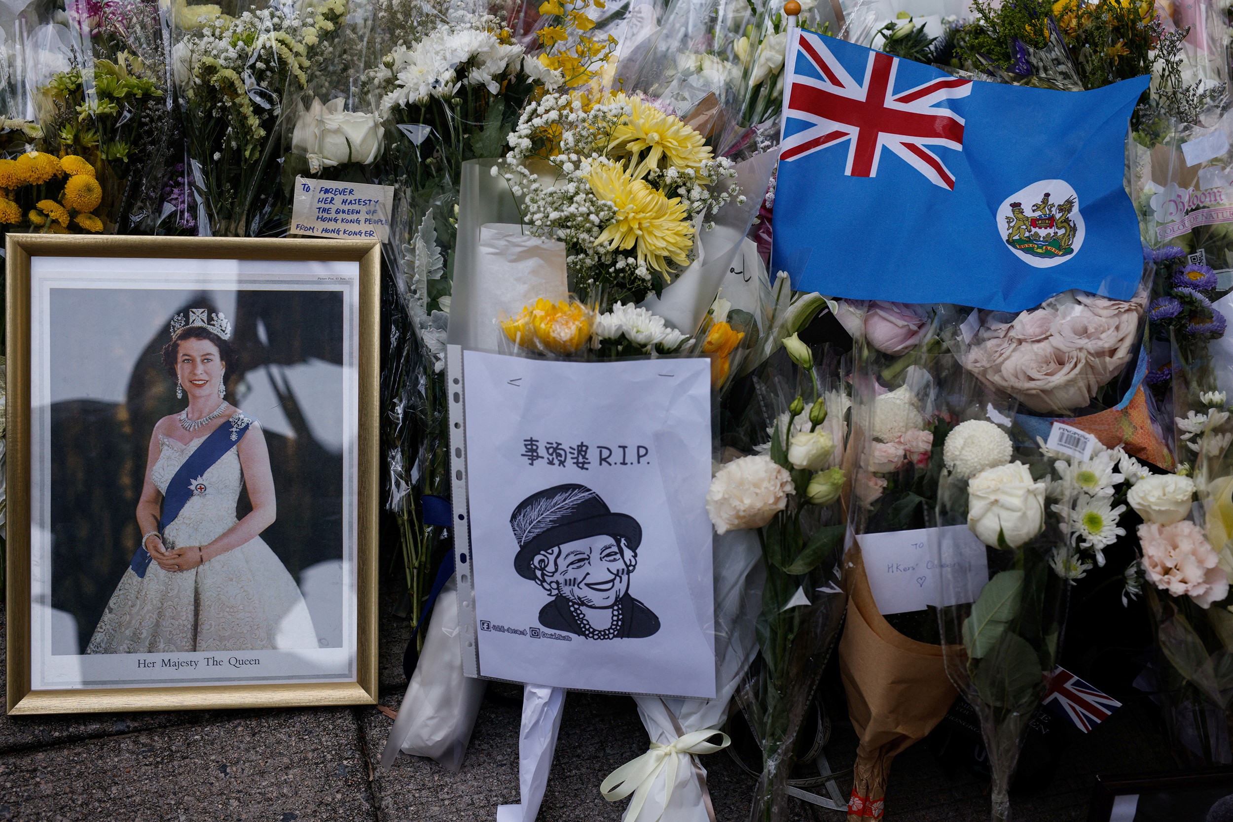 Colonial flag of Hong Kong and images of Britain's Queen Elizabeth are placed outside the British Consulate-General, after she died aged 96, in Hong Kong, China September 12, 2022. REUTERS/Tyrone Siu