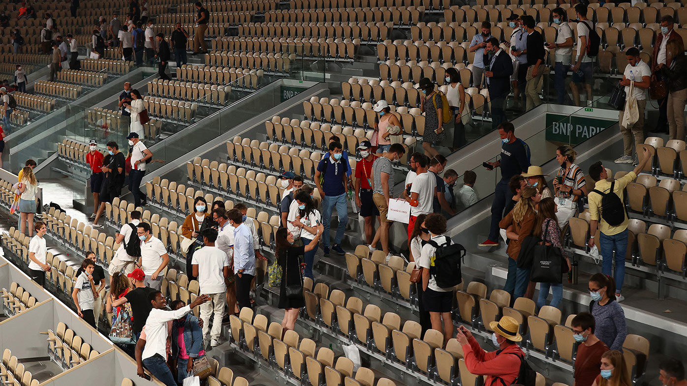 Play is suspended with fans being made to leave the stadium due to government curfew restrictions during the Mens Singles Quarter-Final match between Novak Djokovic of Serbia and Matteo Berrettini of Italy at Roland-Garros.
